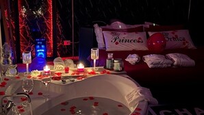 Eine romantische Atmosphäre mit einer Badewanne, gefüllt mit Rosenblättern, Kerzen und einem Schild mit der Aufschrift "Prinzessin".