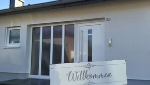 A house with a 'Willkommen' sign in front. - Holiday Apartment Falkenlay (Bad Bertrich)