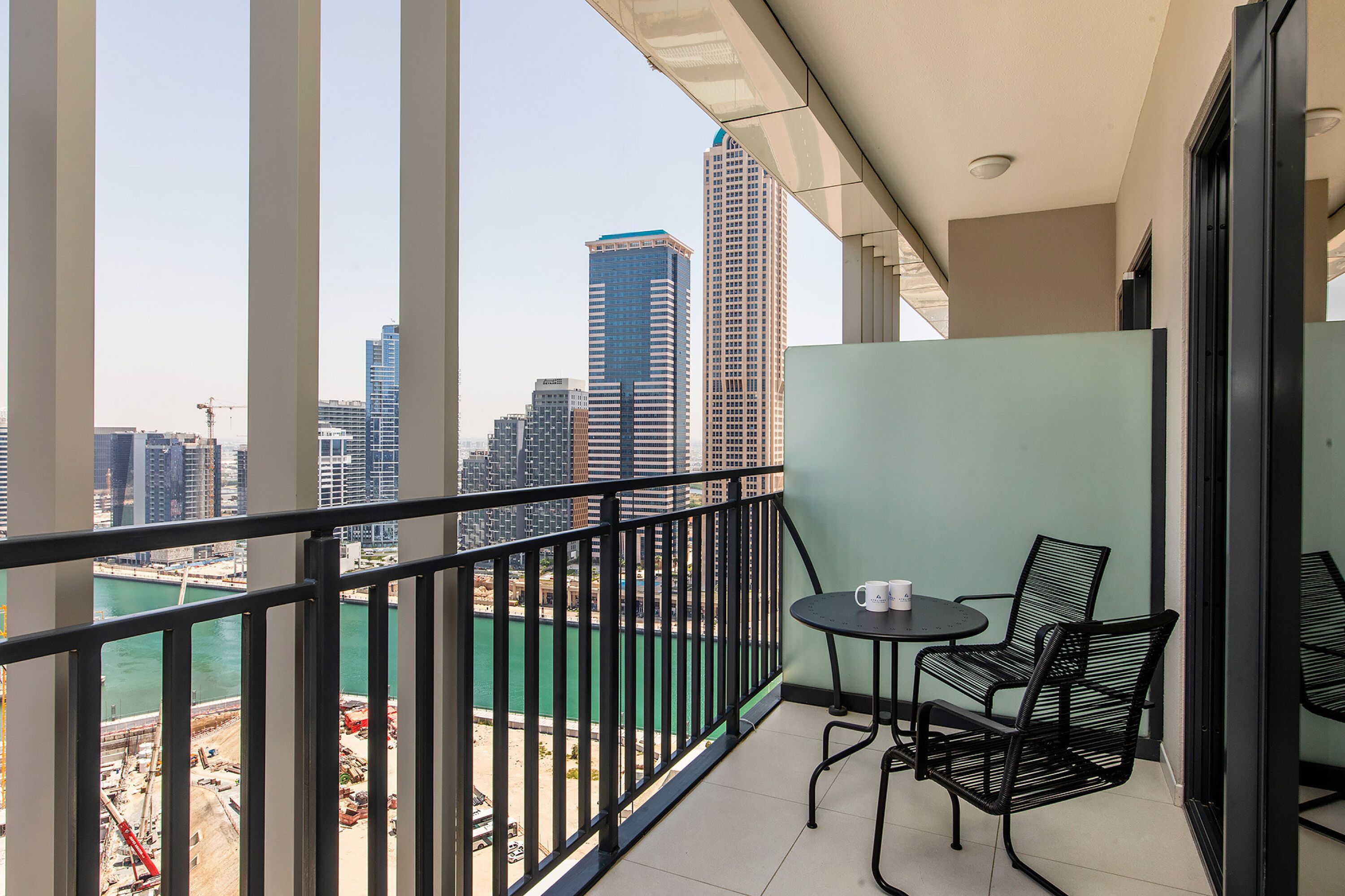 A balcony with a view of a cityscape and a body of water.