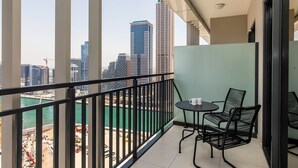 A balcony with a view of a cityscape and a body of water. - Zada Tower 1BR (Dubai)
