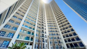 A high-rise building with multiple balconies and a clear sky. - Zada Tower 1BR (Dubai)