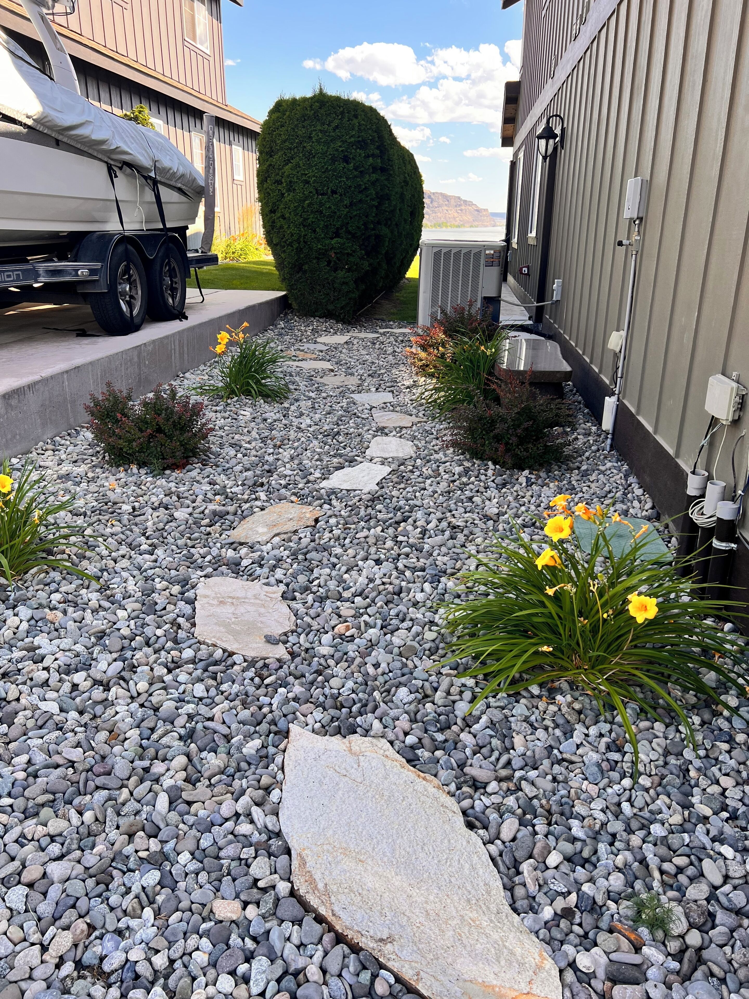 A gravel pathway with stepping stones leading to a building entrance.