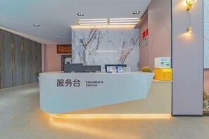 A reception desk with a marble top, a computer, and a small plant. - Dali Teng'ange Smart Hotel (Dali High-speed Railway Station) (Dali City)