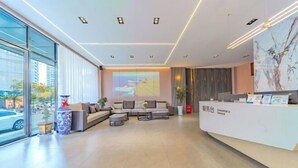 A modern reception area with a sofa, coffee table, and a reception desk. - Dali Teng'ange Smart Hotel (Dali High-speed Railway Station) (Dali City)