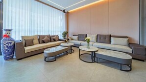 A modern living room with a sofa set, two coffee tables, and a decorative vase. - Dali Teng'ange Smart Hotel (Dali High-speed Railway Station) (Dali City)