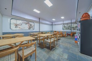 A classroom with wooden desks and chairs, a blackboard with a painting, and a refrigerator on the right. - Dali Teng'ange Smart Hotel (Dali High-speed Railway Station) (Dali City)