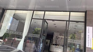 A hotel entrance with glass doors, a reception desk, and a sign with Chinese characters. - Dali Teng'ange Smart Hotel (Dali High-speed Railway Station) (Dali City)