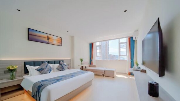 A modern hotel room with a large bed, a flat-screen TV, a sofa, and a large window with curtains. - Dali Teng'ange Smart Hotel (Dali High-speed Railway Station) (Dali City)