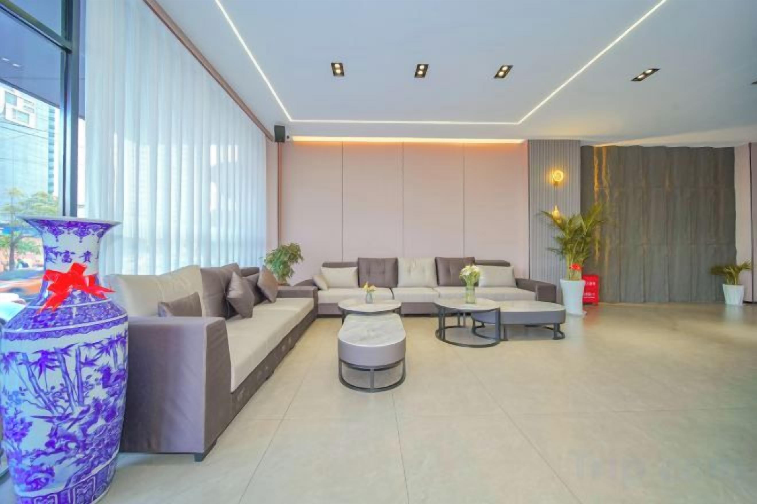 A modern living room with a sofa set, a coffee table, and a decorative vase.