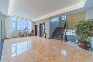 A spacious lobby with a polished floor, a staircase, and a large window offering a view. - Dali Teng'ange Smart Hotel (Dali High-speed Railway Station) (Dali City)