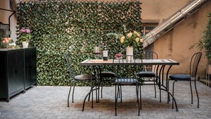 An outdoor patio with a table and chairs, a decorative wall, and a staircase. - Cozy apartment with terrace suitable for families up to 6 people  (Roma)