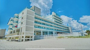 Ein mehrstöckiges Hotel mit modernem Design, mit Balkonen und großen Fenstern.