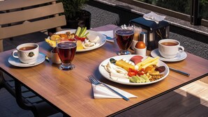 Una mesa con comida y bebidas, con vista a una playa y al paisaje urbano.