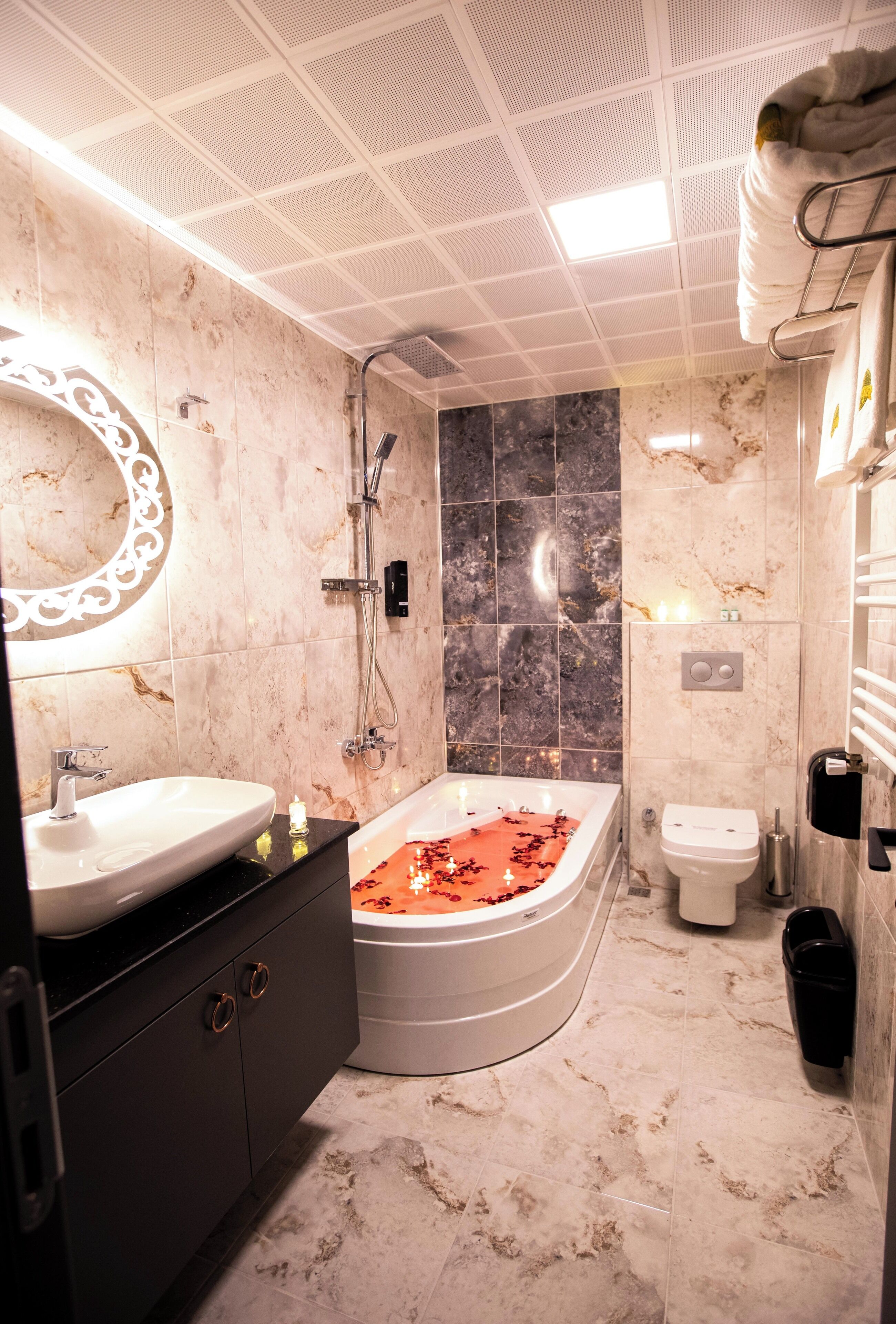 A bathroom with a freestanding bathtub, a vanity with a sink, a mirror, and a shower area.