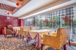 A restaurant with tables and chairs, large windows, and a patterned carpet. - Fengquan Hotel Changsha (Changsha)