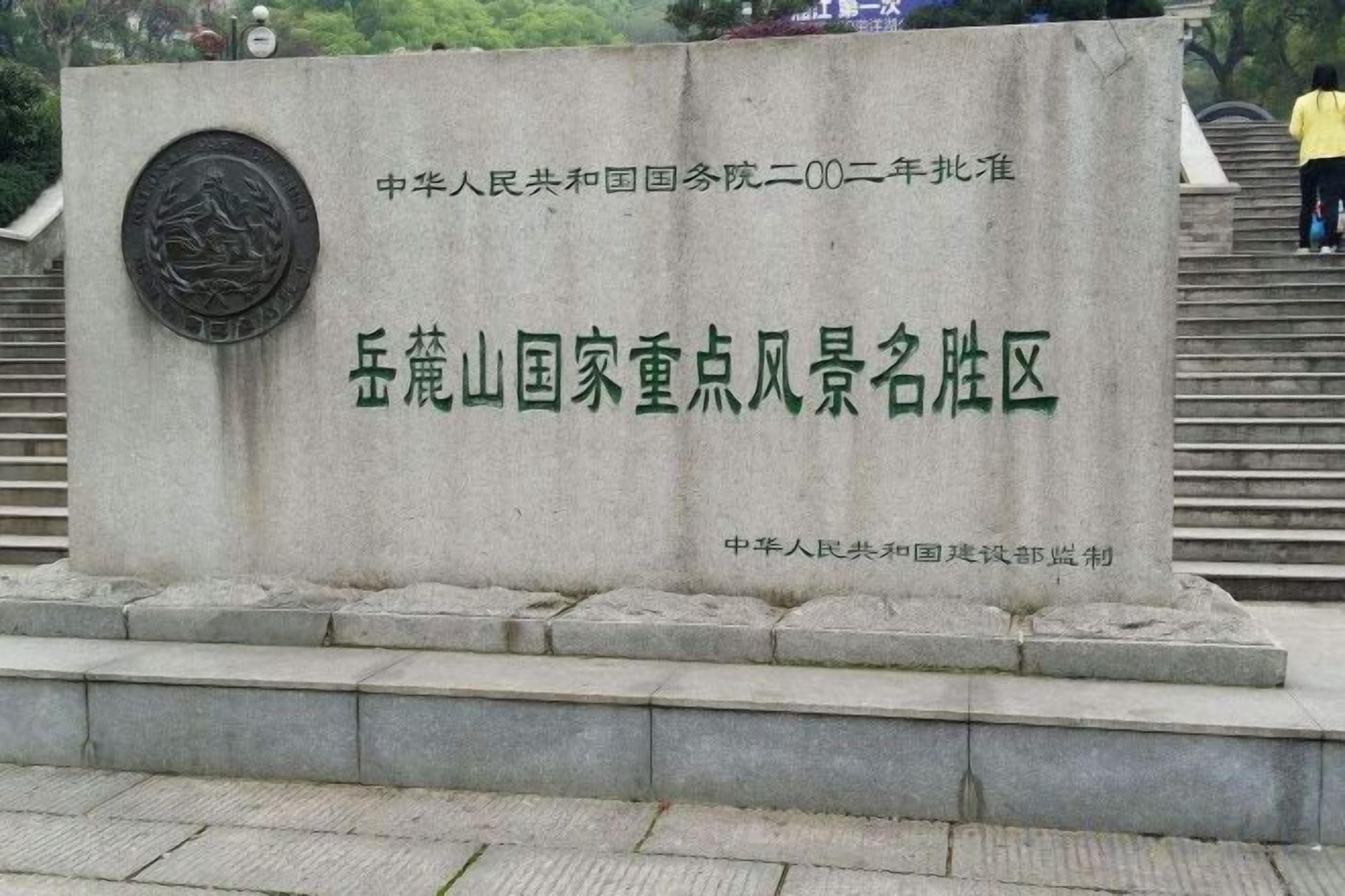Monumento de piedra con inscripciones, situado en un espacio público con escalones que conducen hasta él.