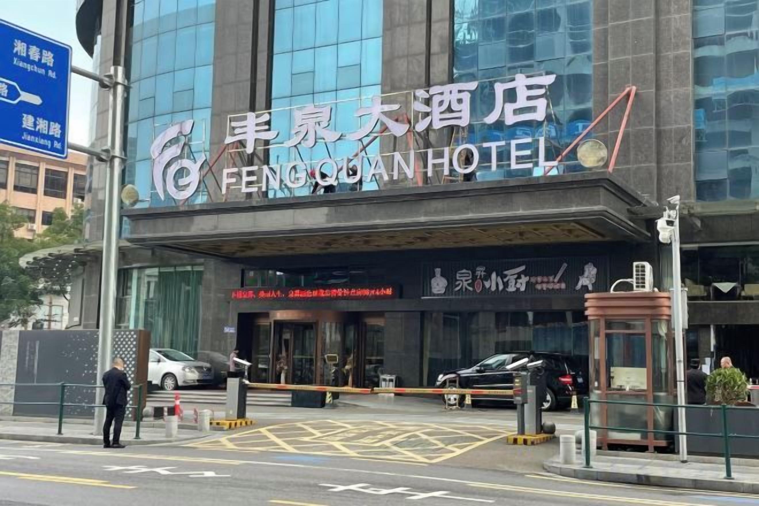 A hotel entrance with a sign reading 'FENGQIAN HOTEL' and a visible entrance gate.
