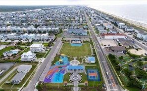 Vista aérea de uma área residencial com casas, um parquinho e uma rua.