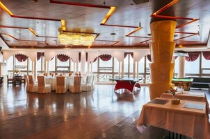 A spacious indoor area with a high ceiling, multiple tables, and chairs arranged for dining.