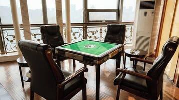 A room with a pool table, four chairs, and a large window with a view.