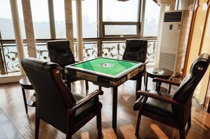Una habitación con mesa de billar, cuatro sillas y un ventanal con vistas.