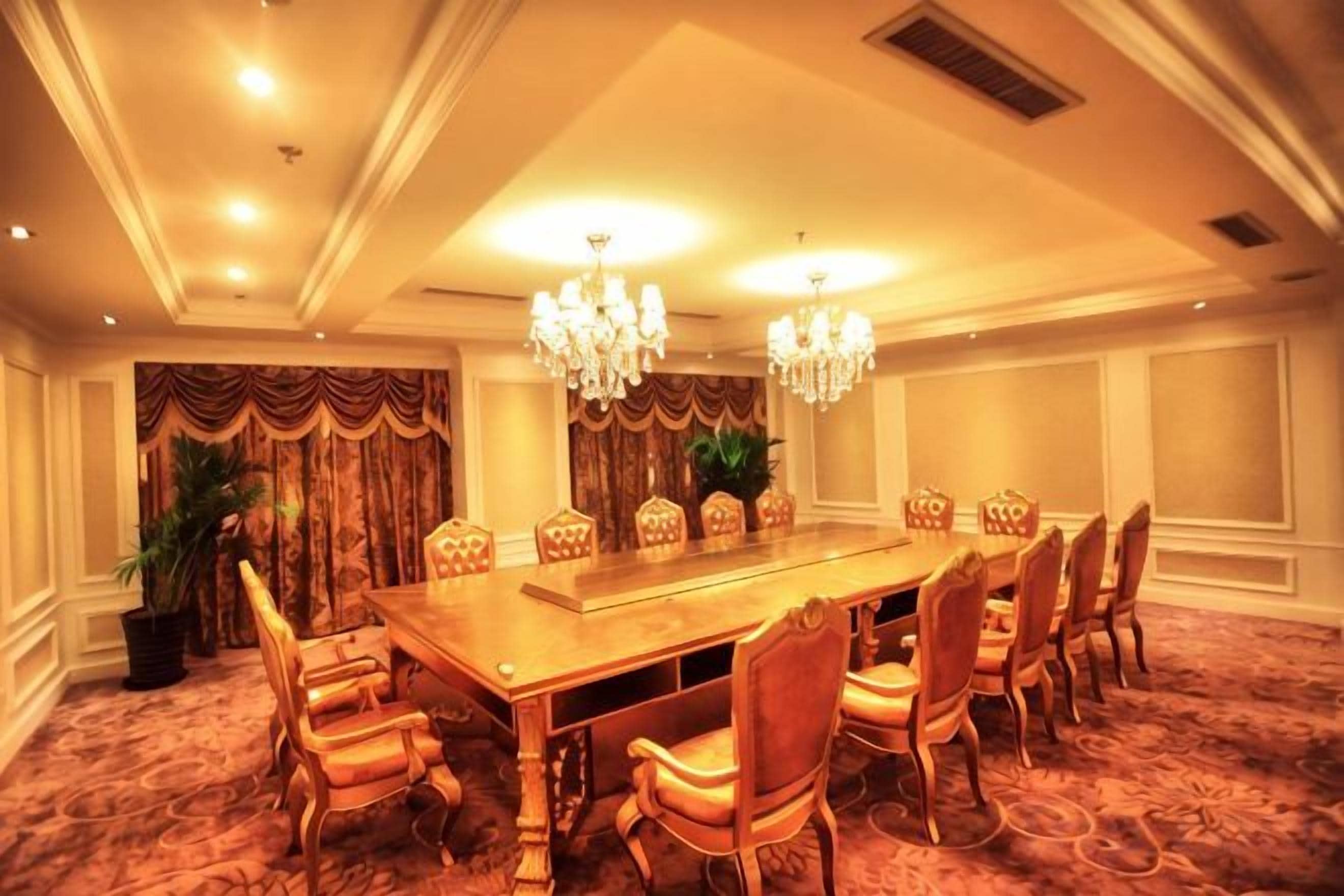 Un comedor formal con una larga mesa, múltiples sillas y candelabros.