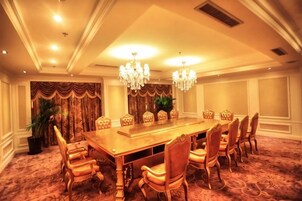 Un comedor formal con una larga mesa, múltiples sillas y candelabros.