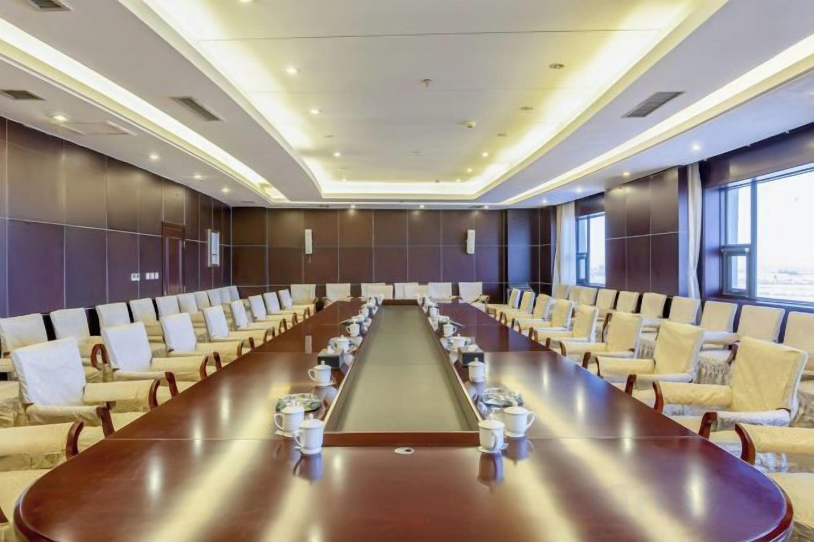 A conference room with a long table, multiple chairs, and a modern design.