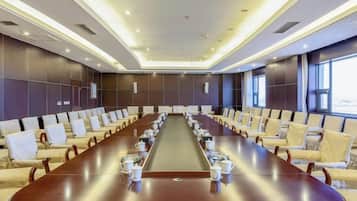 A conference room with a long table, multiple chairs, and a modern design.