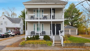 A two-story house with a front porch, a garage, and a driveway.