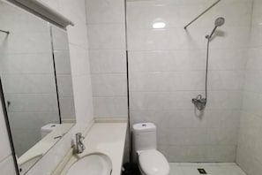Un baño con inodoro, lavabo y ducha.