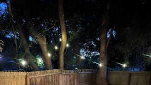 An outdoor seating area with a fire pit, two Adirondack chairs, and a potted plant. - 1BR Modern Bungalow close to Fishing, Navy Base and Ocean (Jacksonville)
