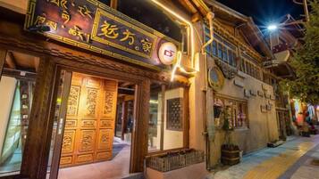 Un bâtiment traditionnel avec une porte en bois et une enseigne lumineuse.