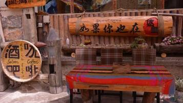 A rustic wooden table with a plaid tablecloth, surrounded by wooden stools and a sign indicating a coffee and saloon.