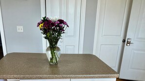 Eine Küche mit Granit Arbeitsplatte, weißen Schränken und einem Blumenstrauß auf der Arbeitsfläche.