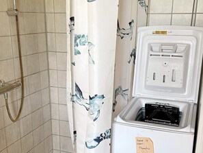Un baño con ducha, inodoro y toallero.