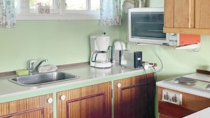 A compact kitchen with a sink, a coffee maker, a toaster, and a stove. - 4 Person Holiday Home in Frorup (Frørup)