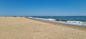 A wide sandy beach with gentle waves and a clear blue sky. - Bungalow in Ayamonte Near Portugal Border (Ayamonte)