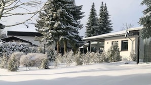 A modern building with a snow-covered landscape, surrounded by evergreen trees. - Holiday Home Kent Comfortable Vacation Home (Willingen)
