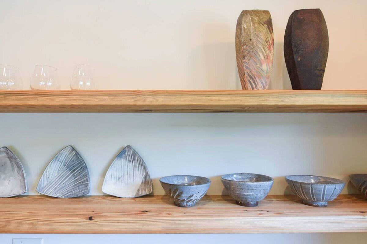 A shelf with various ceramic bowls and vases.