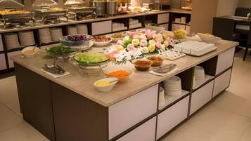 Una mesa de buffet con distintos alimentos y un centro de mesa floral.