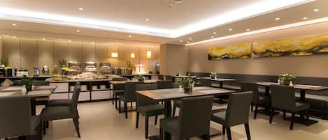 A modern restaurant with a central bar area, multiple seating options including booths and tables, and a minimalist decor with neutral colors.