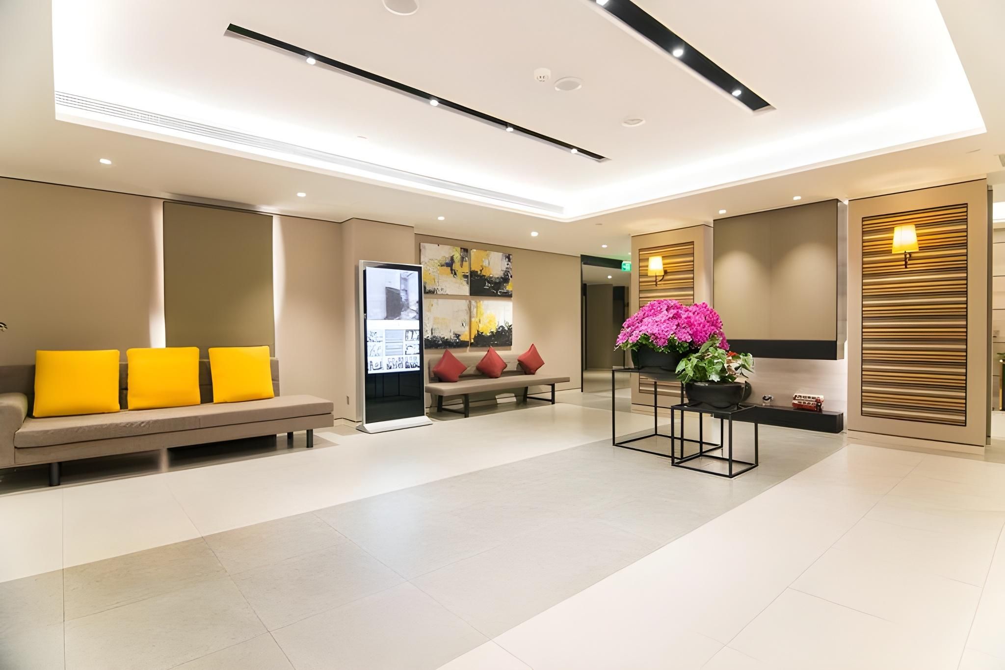 Un vestíbulo moderno de hotel con zona de estar, un mostrador de recepción y un ventanal grande.