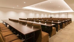 A conference room with long tables and chairs, a flat-screen TV, and a modern ceiling design. - Homeinn Plus Hotel (Beijing Zhongguancun East Road) (Beijing)