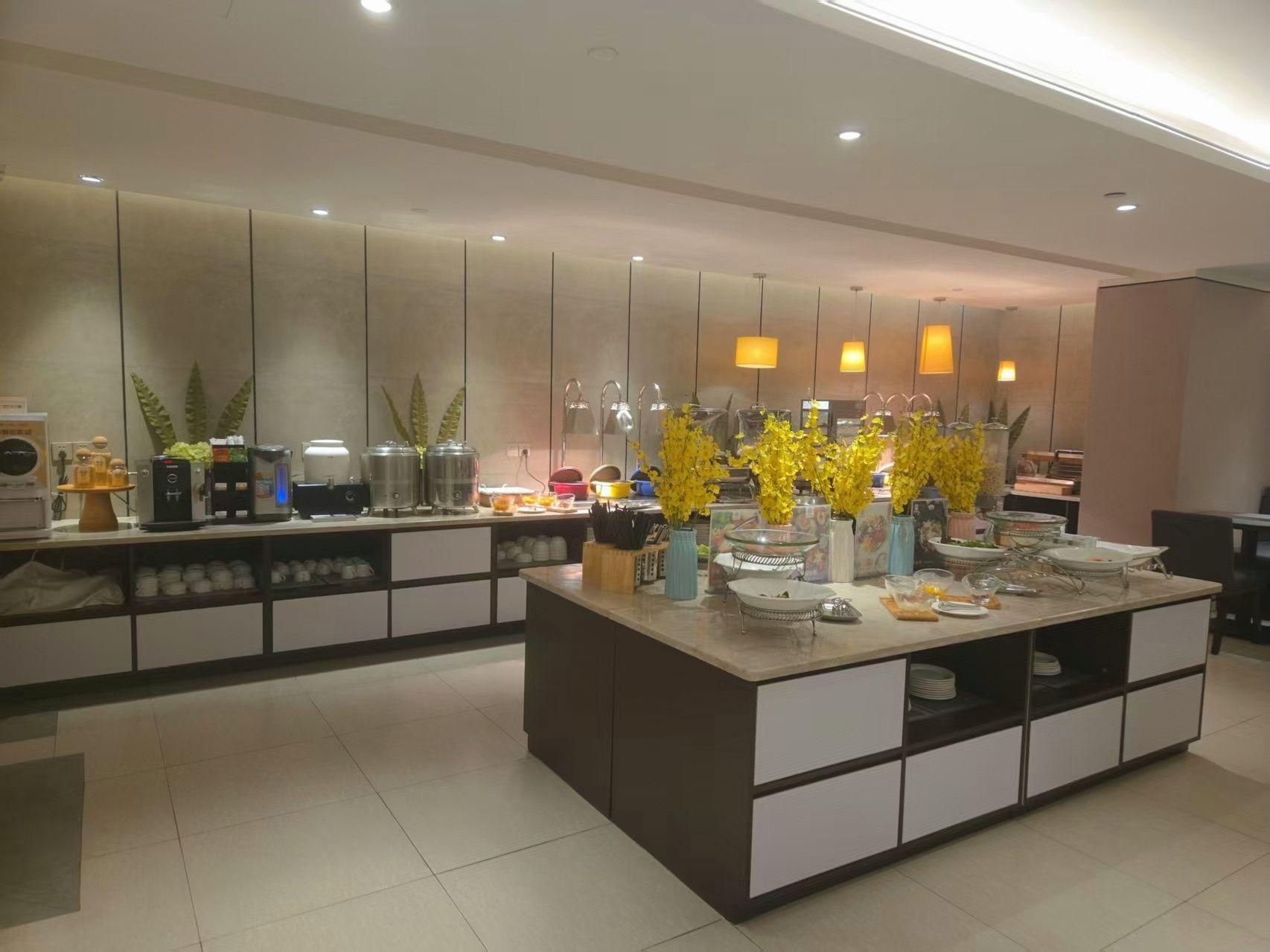 A modern kitchen with a central island, built-in appliances, and decorative plants.