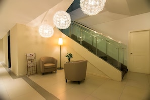 A modern interior with a staircase, a sofa, a lamp, and a plant. - Homeinn Plus Hotel (Beijing Zhongguancun East Road) (Beijing)