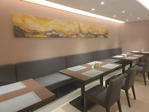 A modern dining area with booths and tables, equipped with place settings and a decorative wall. - Homeinn Plus Hotel (Beijing Zhongguancun East Road) (Beijing)