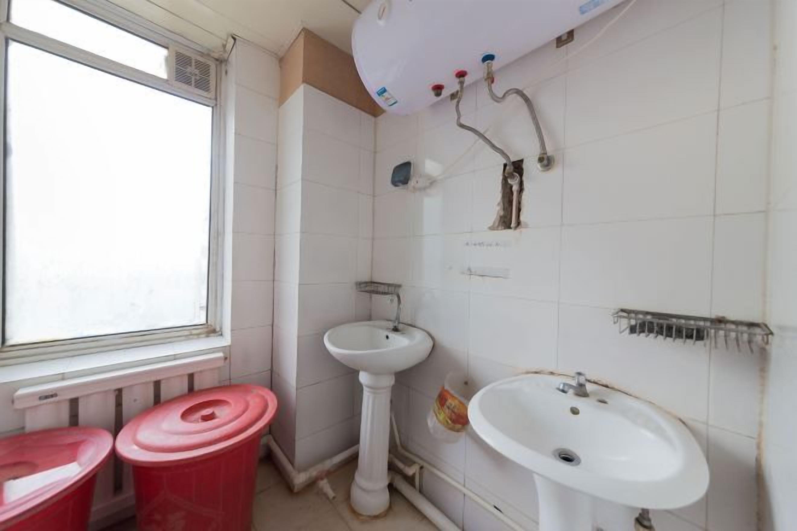 Un baño con ventana, dos lavamanos y ducha.
