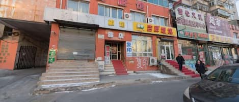 Una calle con varios locales comerciales, incluyendo una farmacia y un restaurante.