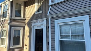 A two-story townhouse with a front entrance, a visible nameplate reading "11 CHARTER STREET," and a black door.